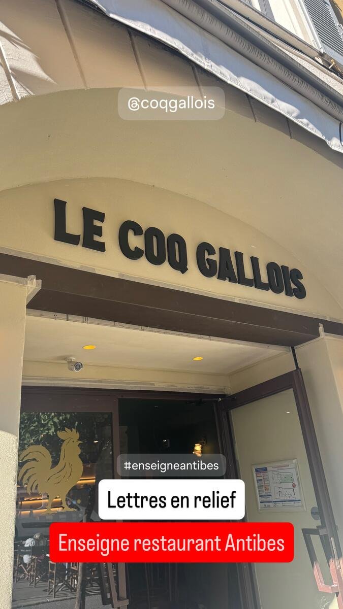 Lettres découpées noires « Le Coq Gallois » posées sous une arcade en pierre
