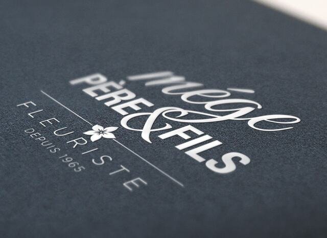 Logo du fleuriste Mège Père & Fils, gaufrage blanc sur papier bleu nuit