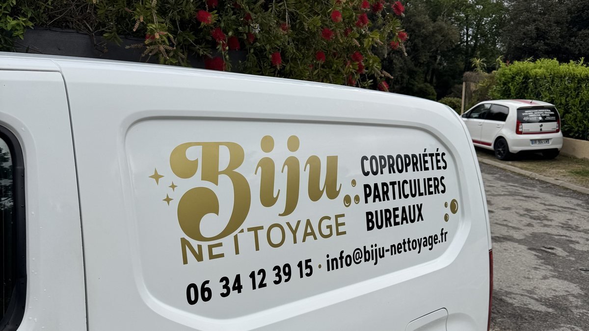 Portes arrière d'un fourgon blanc portant un lettrage adhésif : nom de l'entreprise, activité et numéro de téléphone