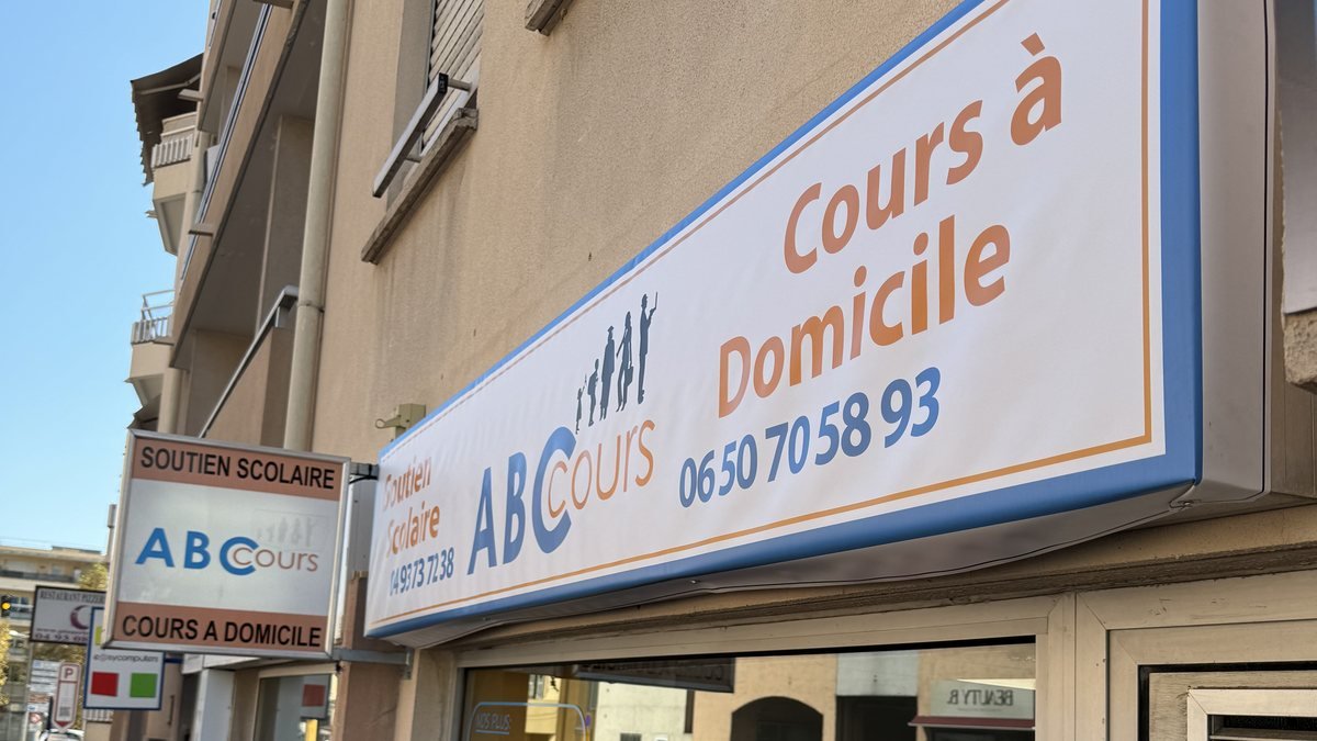 Store banne imprimé avec le nom du commerce posé en devanture, un exemple d'enseigne au sens du code de l'environnement.